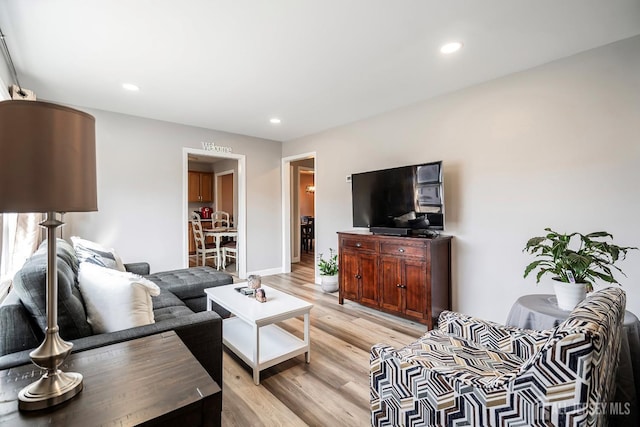 living area featuring recessed lighting, baseboards, and light wood finished floors