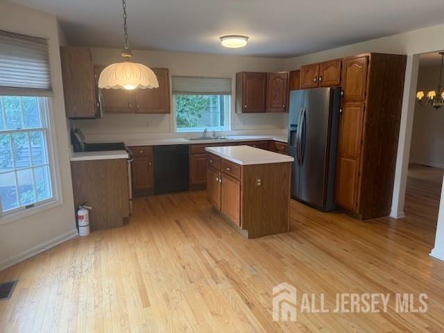 1 Cranberry Ct, South Brunswick, NJ 08540 - kitchen featuring stainless steel fridge with ice dispenser, black dishwasher, a kitchen island, light countertops, and light wood-style flooring