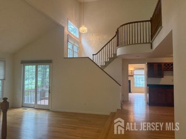 1 Cranberry Ct, South Brunswick, NJ 08540 - unfurnished living room featuring high vaulted ceiling, plenty of natural light, and wood finished floors