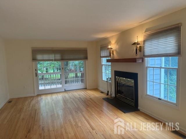 1 Cranberry Ct, South Brunswick, NJ 08540 - unfurnished living room featuring wood finished floors and a glass covered fireplace