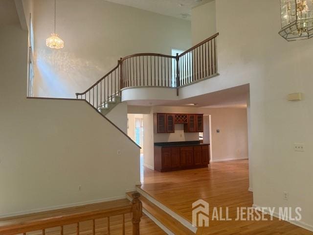 1 Cranberry Ct, South Brunswick, NJ 08540 - staircase featuring a chandelier, wood finished floors, and a high ceiling