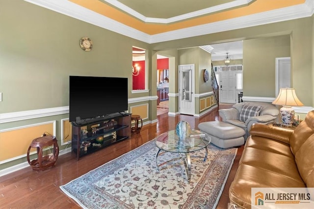 living room with crown molding, baseboards, and wood finished floors