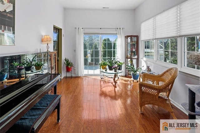 sitting room with baseboards and wood finished floors