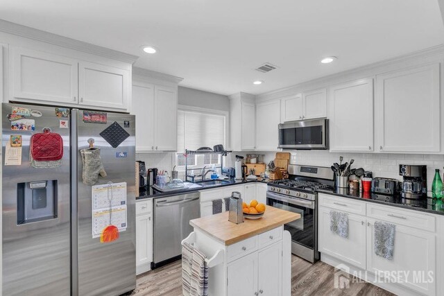 33 Altamont Rd, Edison, NJ 08817 - kitchen with stainless steel appliances, butcher block counters, white cabinetry, decorative backsplash, and light wood-type flooring