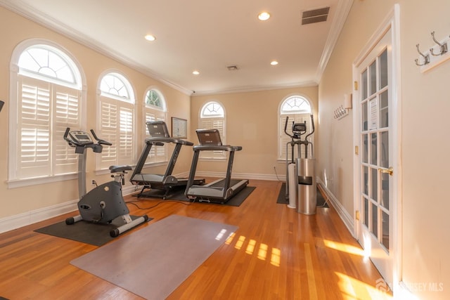 exercise area featuring light wood-type flooring and crown molding