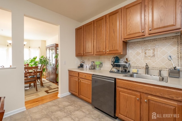 kitchen with decorative backsplash, stainless steel dishwasher, sink, and a healthy amount of sunlight