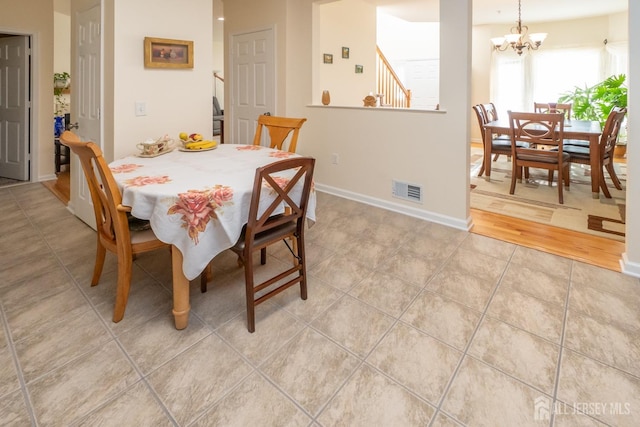 dining room with hardwood / wood-style flooring and a chandelier