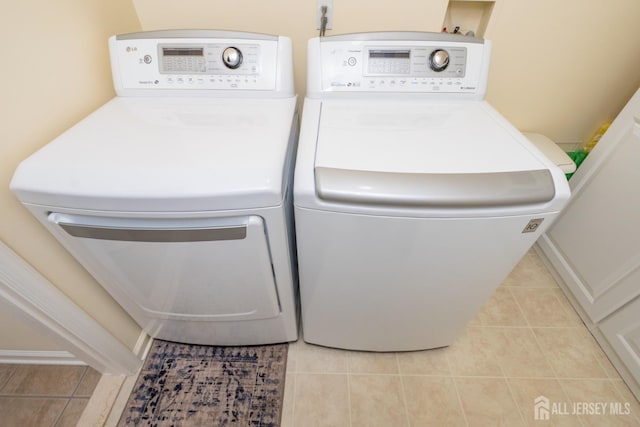 washroom featuring separate washer and dryer and light tile patterned floors