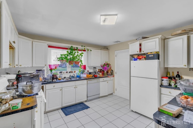 kitchen featuring white cabinetry, sink, light tile patterned floors, and white appliances