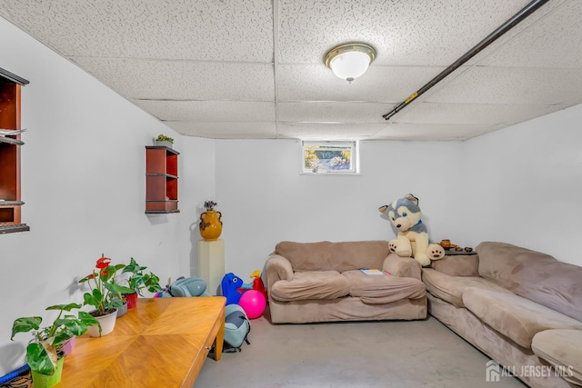 living room with a drop ceiling and concrete floors