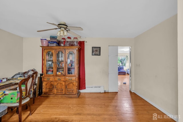 dining space featuring light wood-type flooring, ceiling fan, and baseboard heating