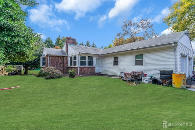 rear view of property with a yard