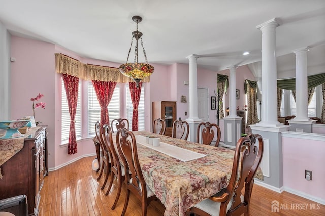 dining space featuring decorative columns, baseboards, and light wood-style flooring