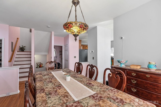 dining room featuring wood finished floors and stairs