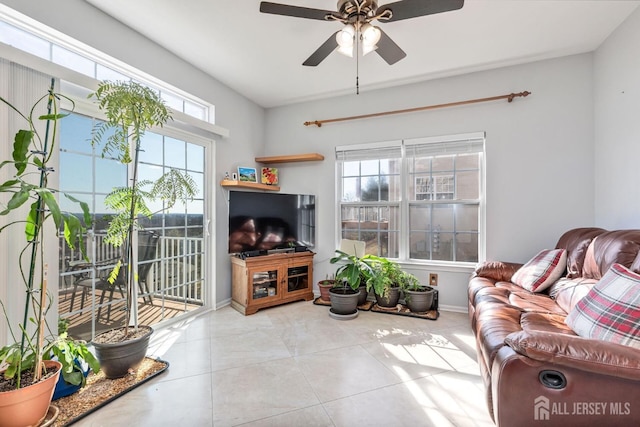 tiled living area with a healthy amount of sunlight, baseboards, and ceiling fan