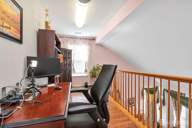 office area featuring visible vents, lofted ceiling, and wood finished floors