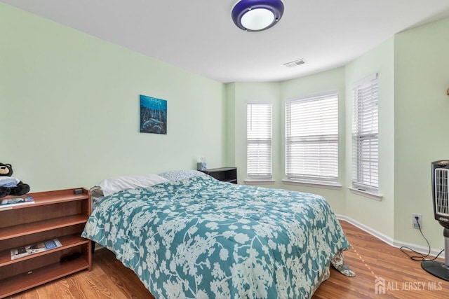 bedroom with baseboards and wood finished floors