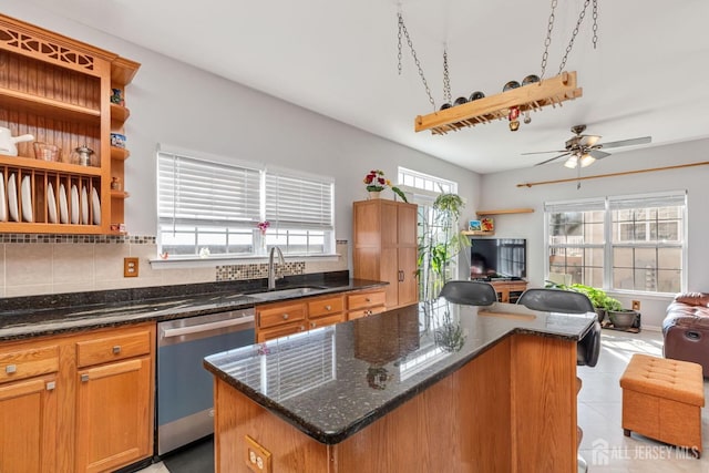 kitchen featuring a kitchen island, a sink, open floor plan, stainless steel dishwasher, and tasteful backsplash