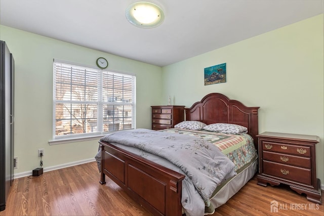 bedroom featuring baseboards and wood finished floors