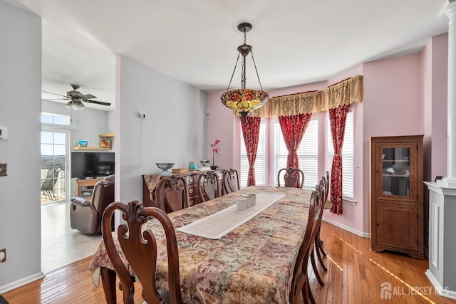 dining area featuring a wealth of natural light, light wood-type flooring, baseboards, and a ceiling fan