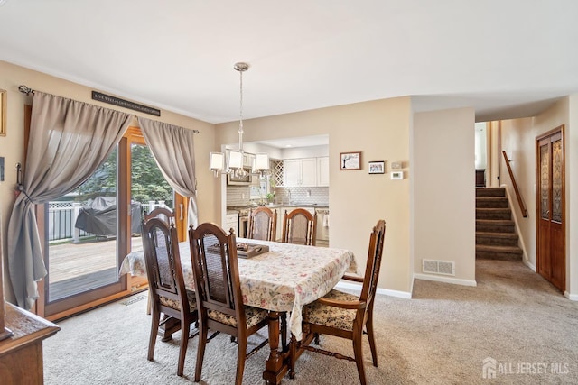 217 Fred Allen Dr, South Plainfield, NJ 07080 - dining space featuring a chandelier, light carpet, and stairway