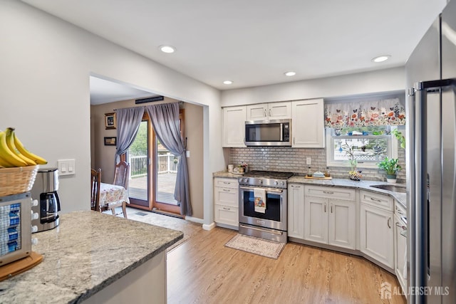 217 Fred Allen Dr, South Plainfield, NJ 07080 - kitchen with appliances with stainless steel finishes, light wood-style floors, light stone counters, decorative backsplash, and recessed lighting