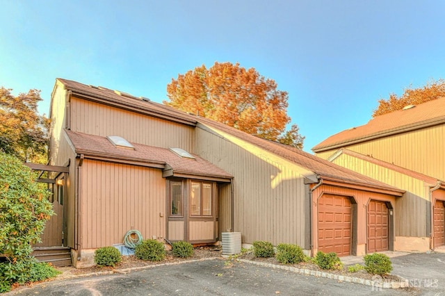 view of side of property featuring central AC and a garage