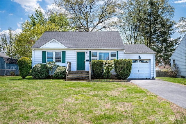 view of front of home featuring a shingled roof, an attached garage, driveway, and a front lawn