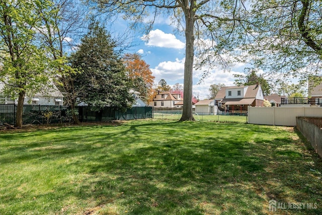 view of yard featuring a fenced backyard and a residential view