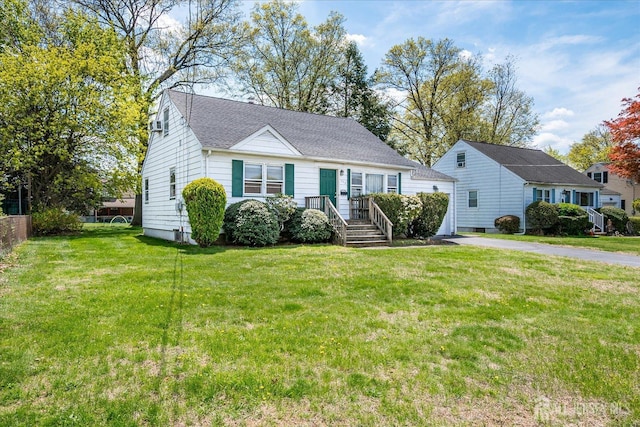 view of front facade featuring roof with shingles and a front lawn