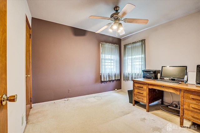 carpeted office space featuring baseboards and ceiling fan