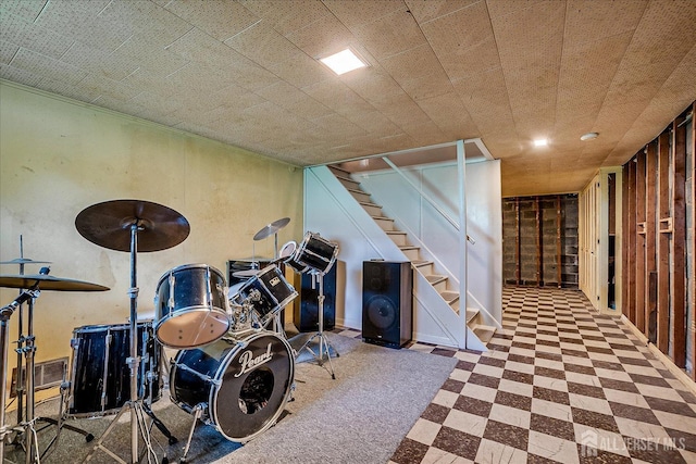finished below grade area with stairway and tile patterned floors