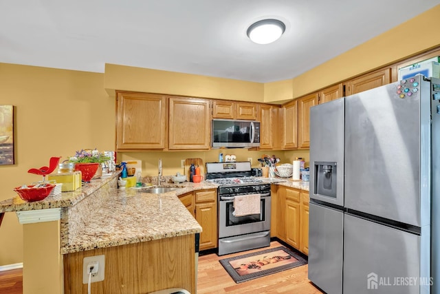 122 Salem Rd, North Brunswick, NJ 08902 - kitchen featuring appliances with stainless steel finishes, a peninsula, light wood finished floors, light stone countertops, and light brown cabinetry