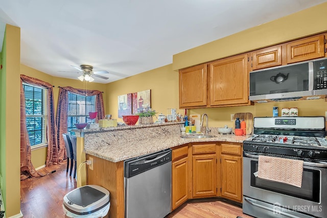 122 Salem Rd, North Brunswick, NJ 08902 - kitchen with appliances with stainless steel finishes, light wood finished floors, a peninsula, light stone countertops, and a ceiling fan