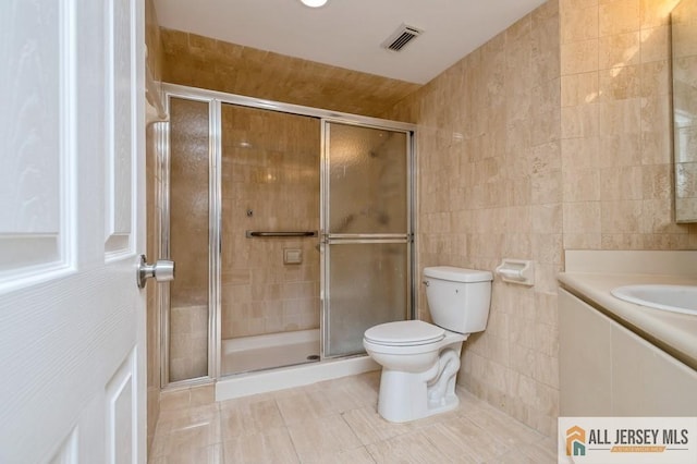 bathroom with visible vents, tile patterned flooring, toilet, tile walls, and a stall shower