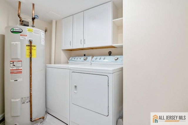 laundry room with cabinet space, water heater, and washing machine and dryer