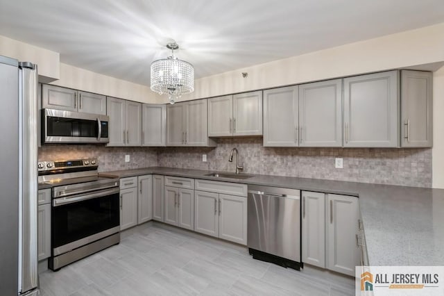 30 S Adelaide Ave Unit 4G, Highland Park, NJ 08904 - kitchen featuring appliances with stainless steel finishes, a sink, a chandelier, and decorative backsplash