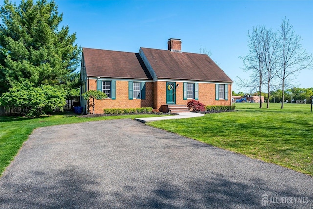 27 Vermont Ave, Franklin, NJ 08823 - view of front of house with brick siding, a chimney, and a front yard