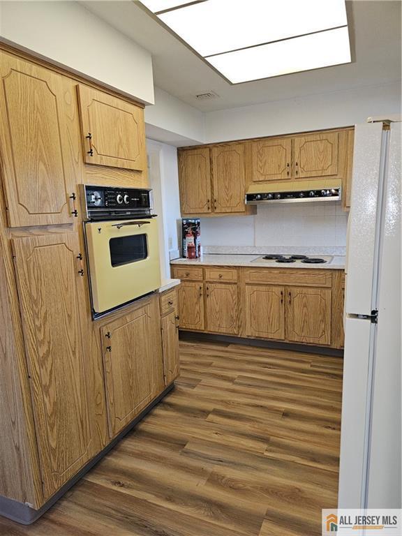 kitchen featuring dark wood-type flooring and white appliances