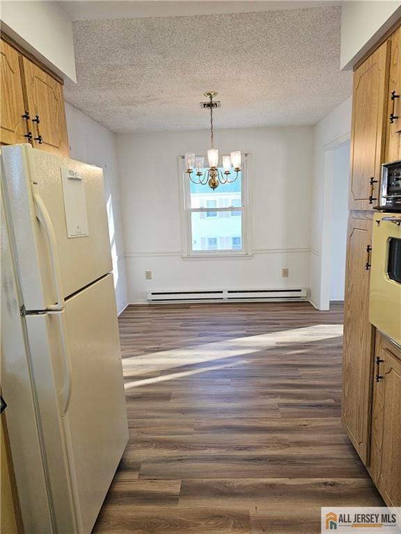 kitchen with a baseboard heating unit, dark wood-style flooring, freestanding refrigerator, and pendant lighting