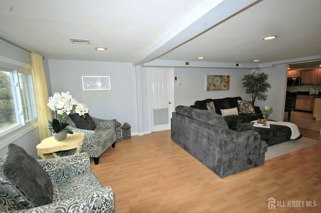 living room with light wood-style flooring, visible vents, and recessed lighting