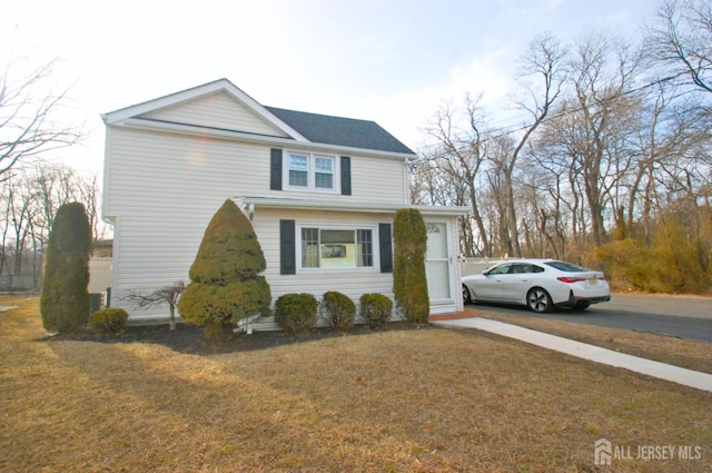 traditional-style home with aphalt driveway and a front yard