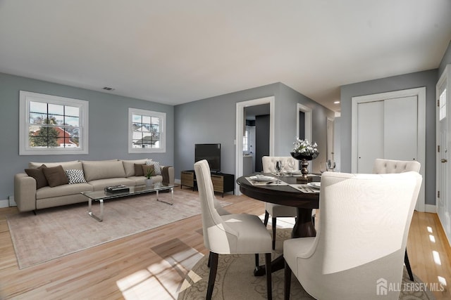 dining space featuring light wood-style flooring and baseboards