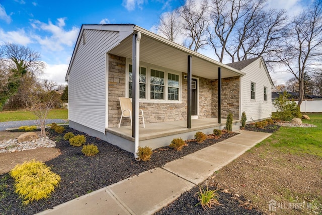 view of side of home featuring a porch and stone siding