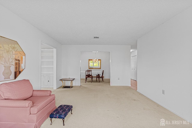 714 Victoria Ct Unit B, Monroe, NJ 08831 - living area with carpet flooring, a textured ceiling, and a chandelier