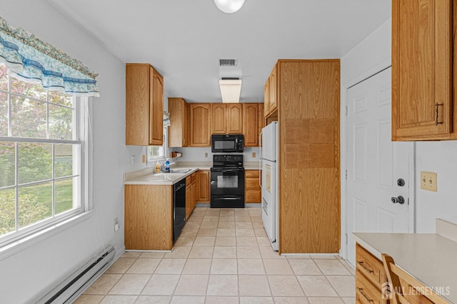 714 Victoria Ct Unit B, Monroe, NJ 08831 - kitchen with black appliances, a baseboard heating unit, a sink, light tile patterned flooring, and light countertops