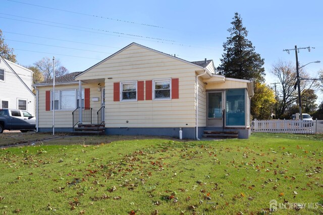 bungalow with a front lawn and a sunroom