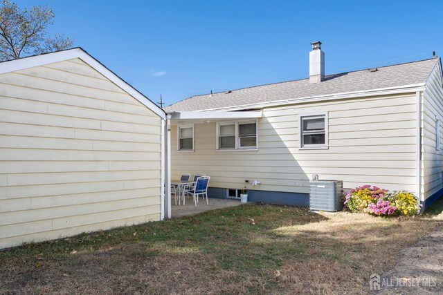 rear view of house with a lawn, a patio, and central air condition unit