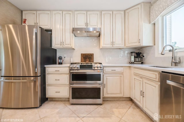 35 Winthrop Dr, Manalapan, NJ 07726 - kitchen with stainless steel appliances, cream cabinets, under cabinet range hood, and a sink