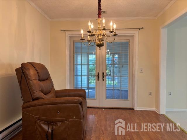 entryway with french doors, wood finished floors, baseboards, a baseboard radiator, and a notable chandelier